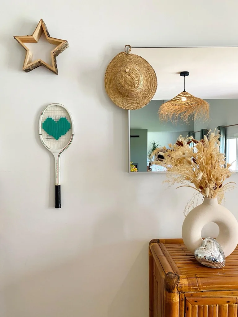 Raquette de tennis vintage au cœur pixel vert, accrochée au mur dans la décoration de Charlotte