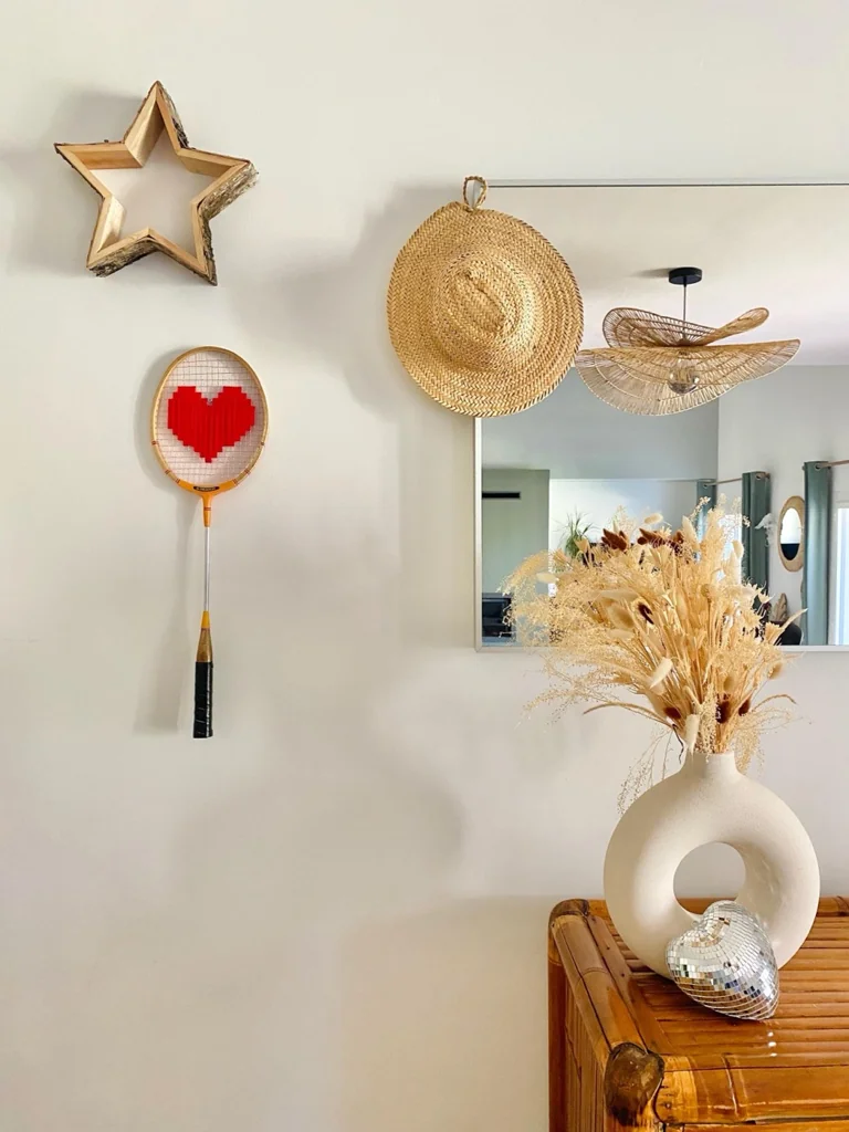 Raquette de badminton vintage au cœur pixel rouge, accrochée au mur dans la décoration de Charlotte