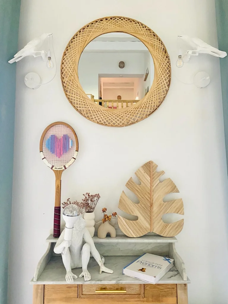 Raquette de tennis vintage au cœur pixel pastel multicolore, accrochée au mur dans la décoration de Charlotte